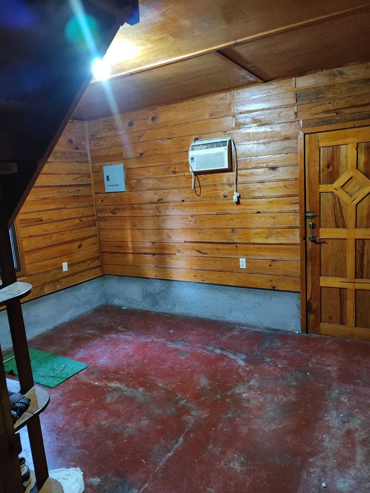 Habitación de cabaña de madera con aire acondicionado, piso rústico y acabados naturales