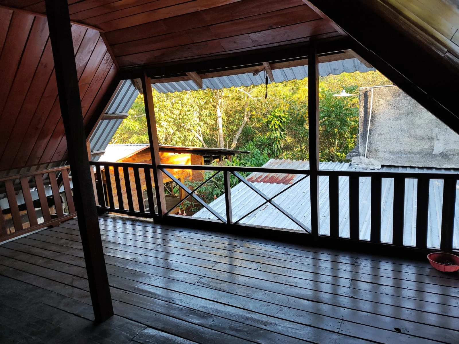 Balcón de madera en cabaña rústica con vista a la vegetación y entorno natural